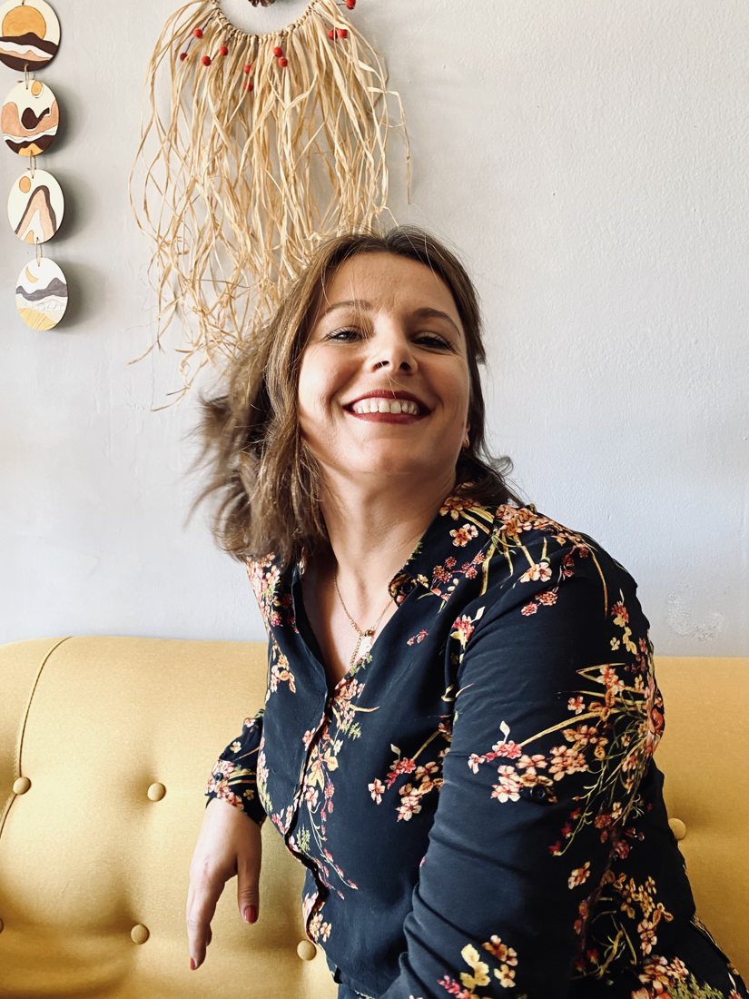 Anna sonriendo en el sofá amarillo de su estudio